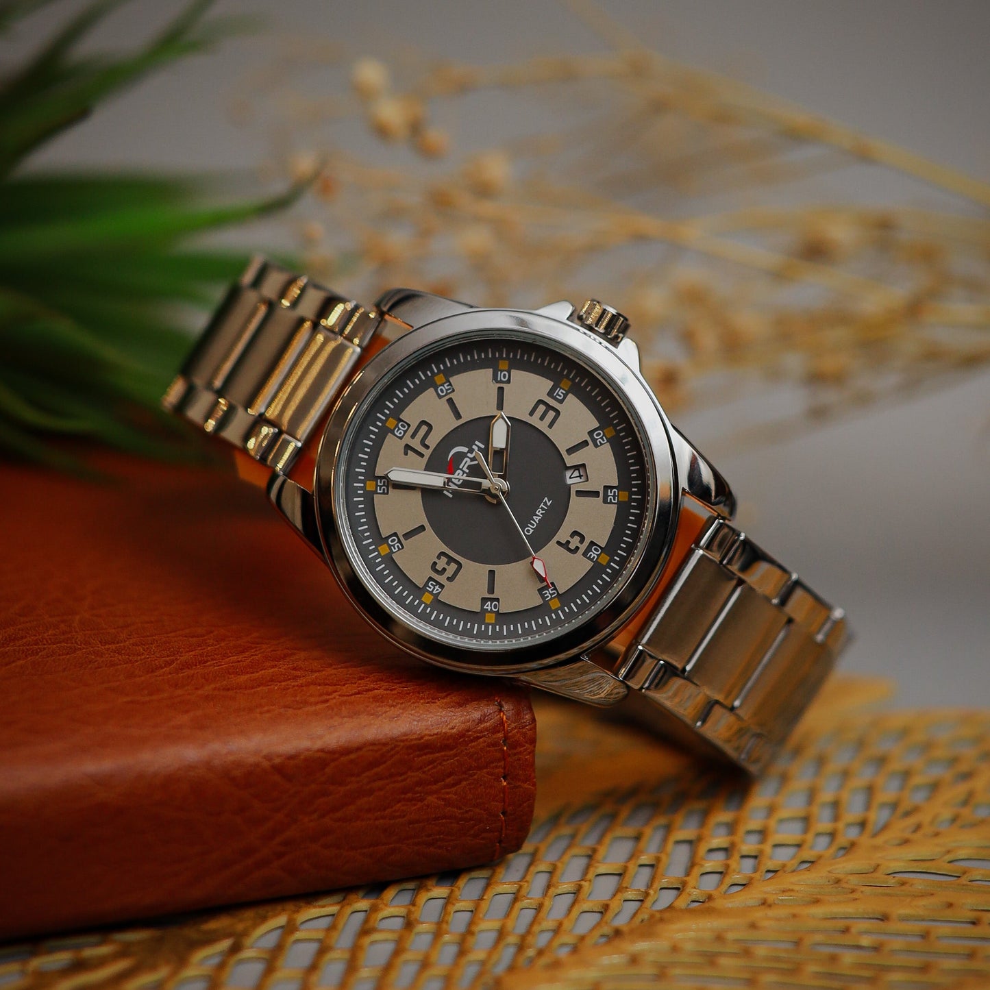 Wristwatch with Gray face and metal band on a textured surface