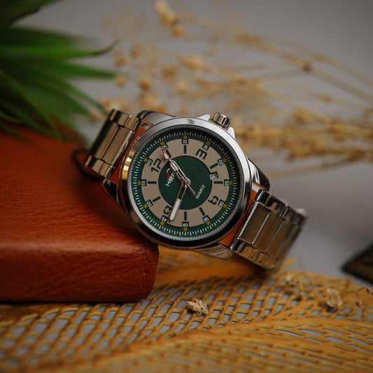 Wristwatch with green face and metal band on a textured surface