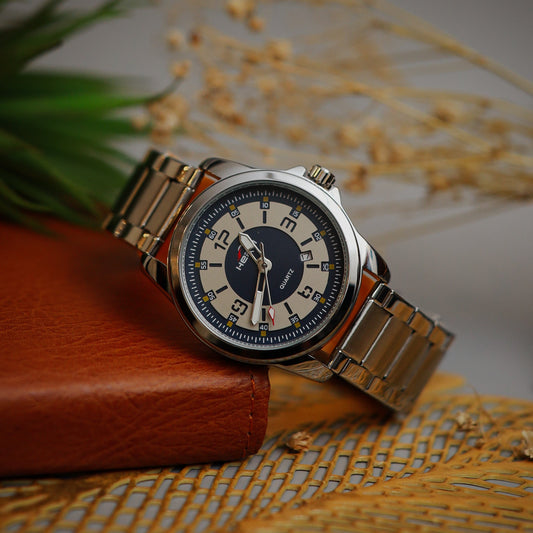 Wristwatch with Navy face and metal band on a textured surface