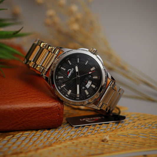 Silver watch with black dial on a textured surface