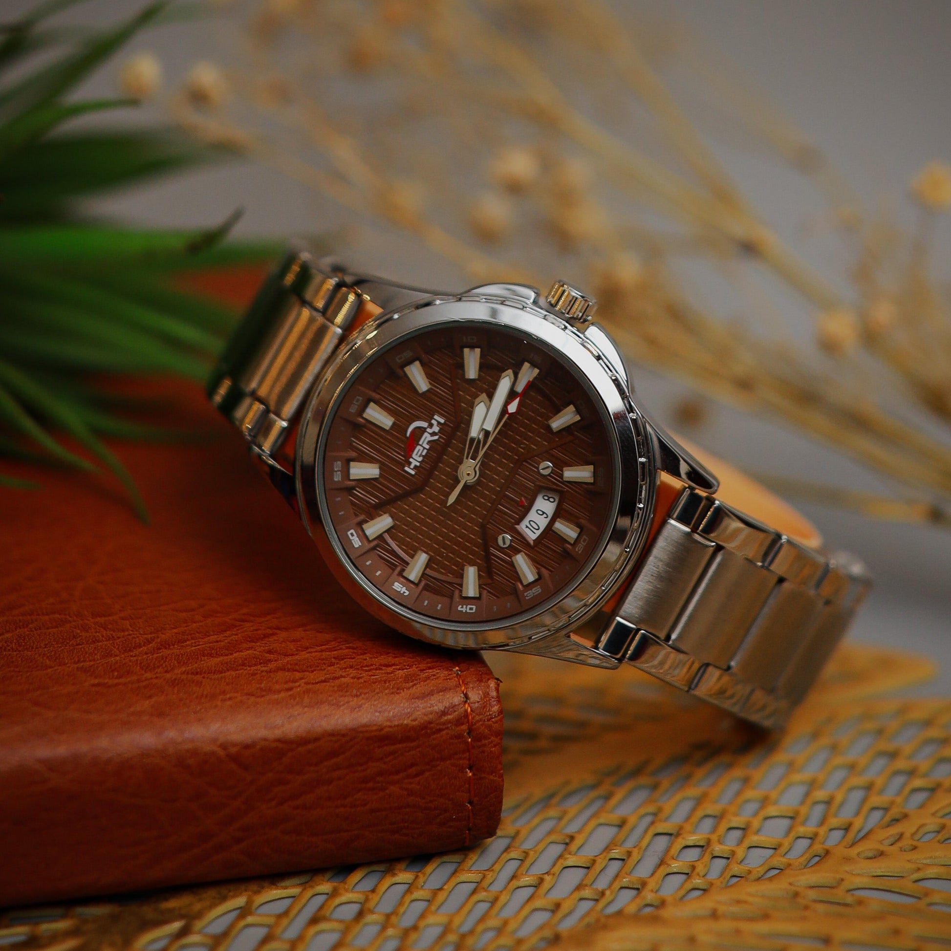 Silver watch with brown dial on a textured surface