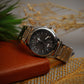 Silver watch with a black face on a textured surface
