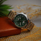 Silver watch with green dial on a textured surface